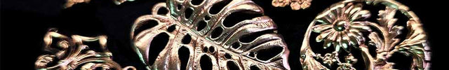 Collection of floral themed metal pieces on a dark background